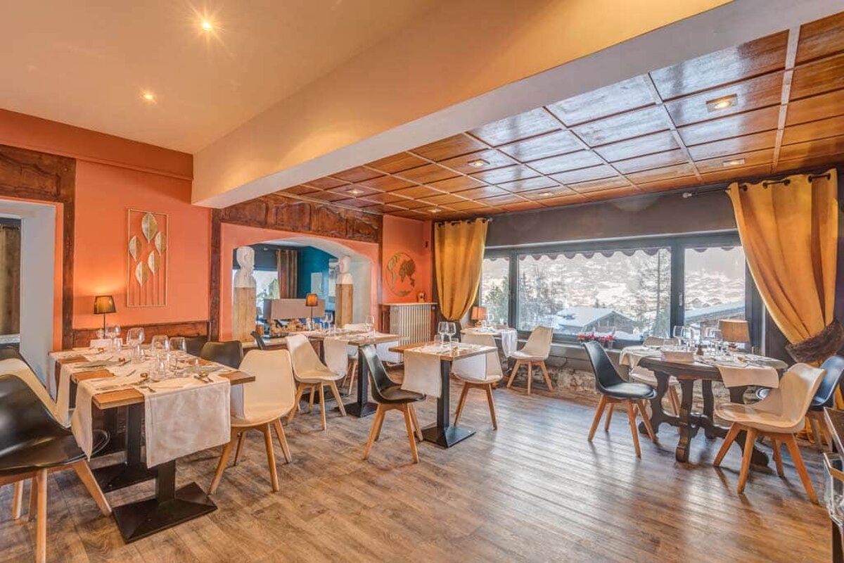 A dining room with tables and chairs and a large window