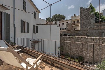 A balcony with chairs and a stone wall