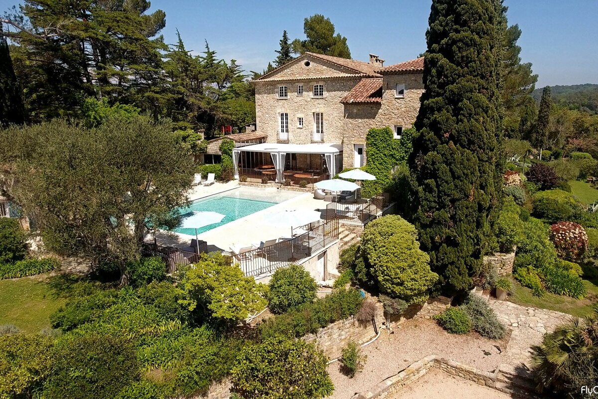 An aerial view of a large house with a large swimming pool