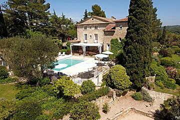 An aerial view of a large house with a large swimming pool