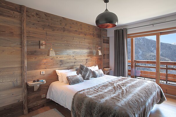A bedroom with a bed and a wooden wall