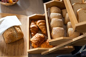 A wooden box filled with bread rolls and croissants