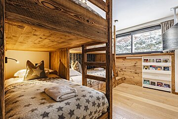 A bunk bed with a blanket with stars on it