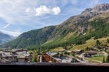 A mountain landscape with a few houses in the foreground