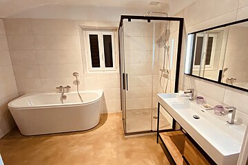 A bathroom with a tub a sink and a shower