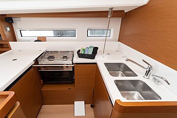 A kitchen with two sinks and a stove top oven