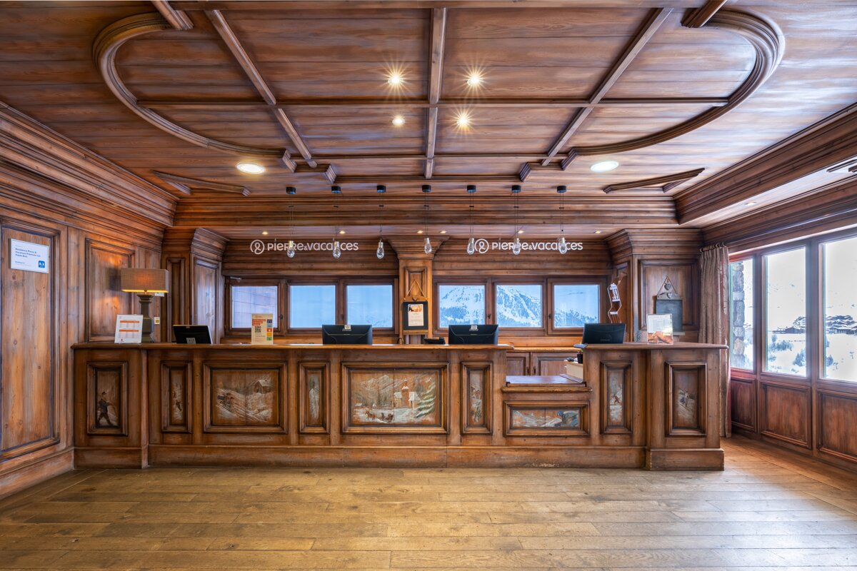 A wooden lobby with a sign that says pierre & vacances