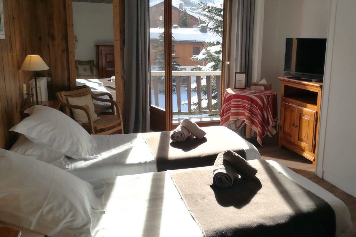 A hotel room with two beds and a television
