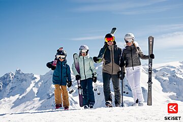 A group of skiers standing on top of a snow covered mountain