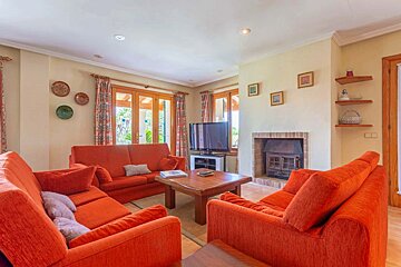 A living room with orange furniture and a fireplace