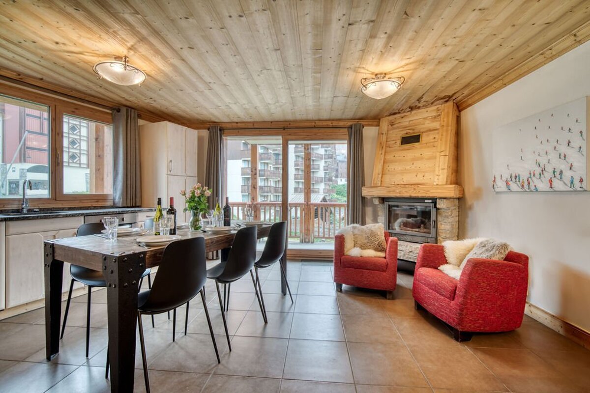 A living room with a table and chairs and a fireplace