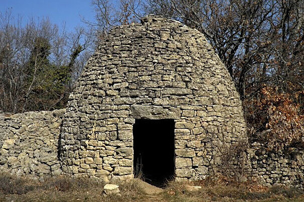 A stone building with a door and trees in the background