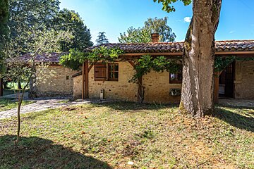 A stone house with a tree in front of it