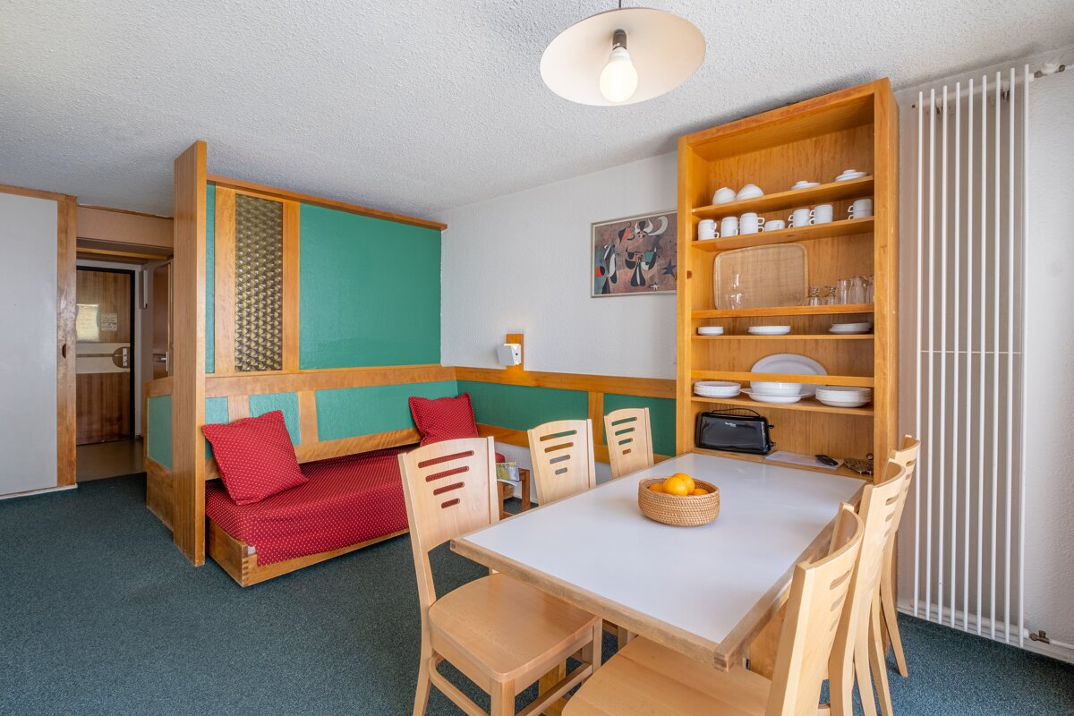 A living room with a dining table and chairs