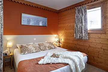 A bedroom with a bed and a picture on the wall