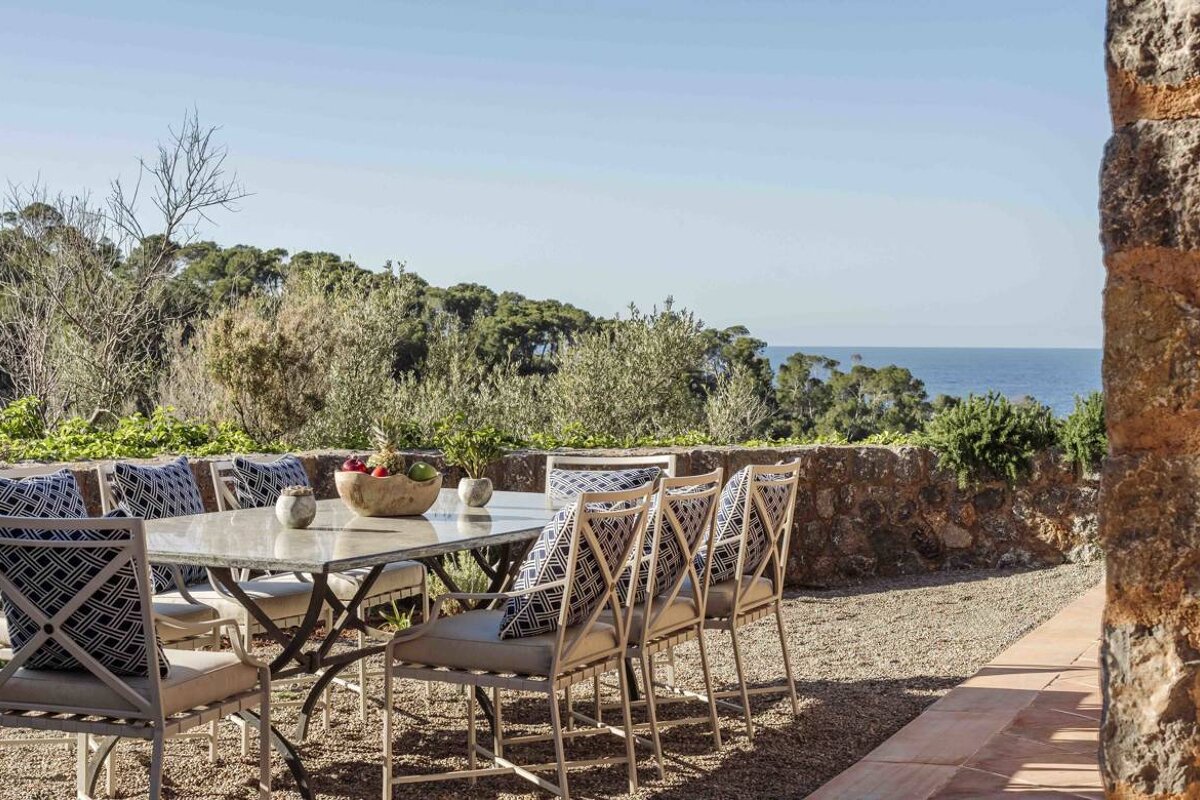 A table and chairs with a view of the ocean