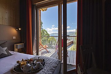 A hotel room with a tray of food on the bed