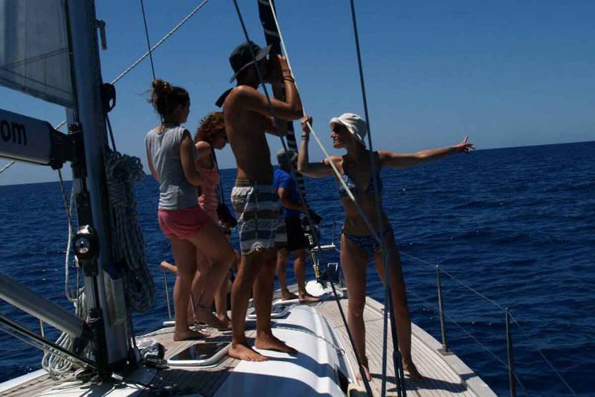 A group of people on a boat with a sign that says water.com