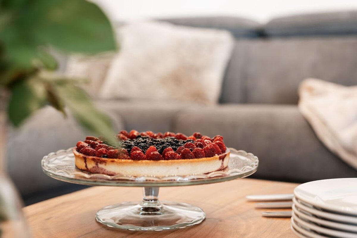 A cheesecake with raspberries and blackberries on top of it