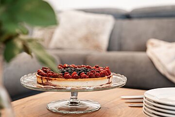 A cheesecake with raspberries and blackberries on top of it