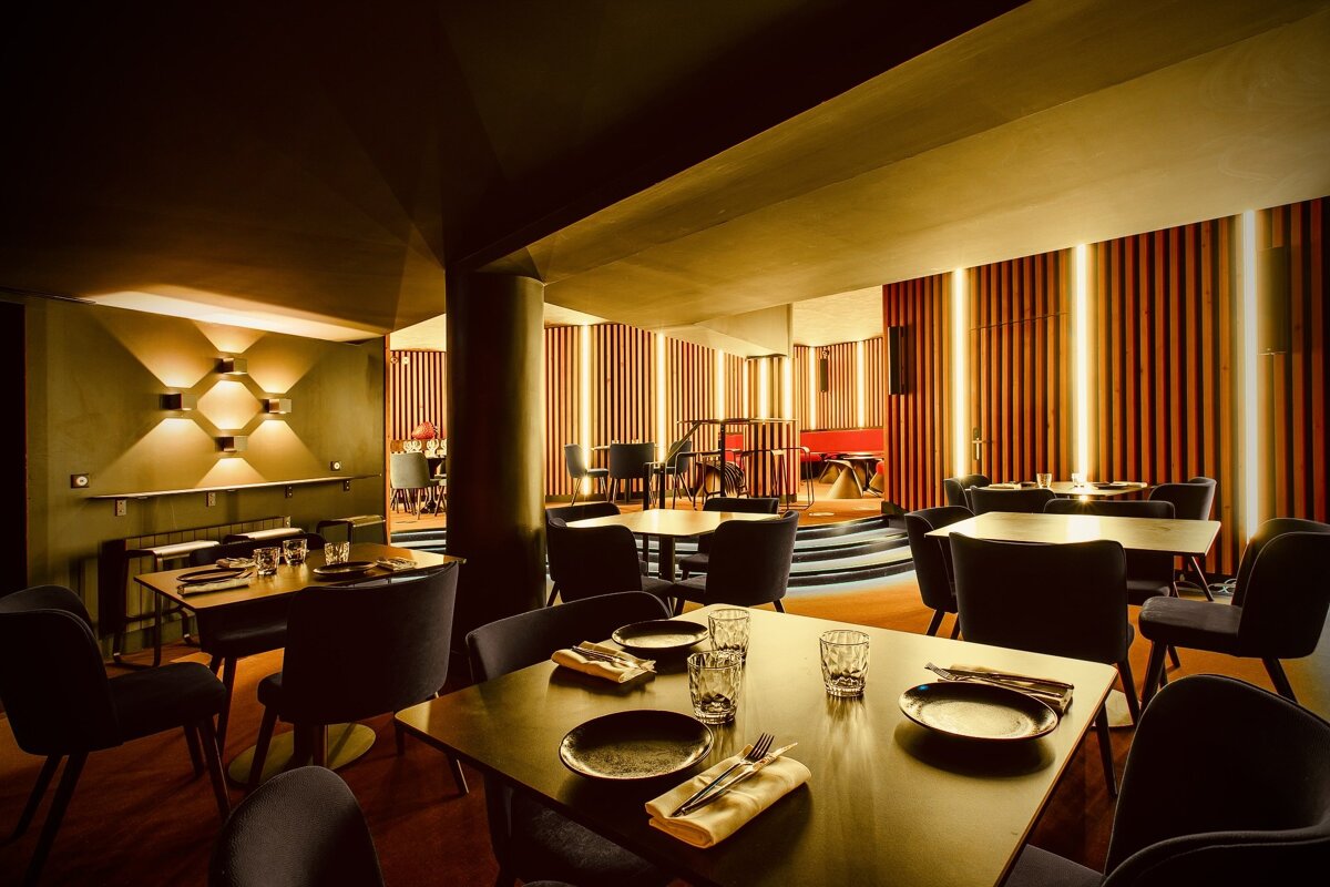 A restaurant with tables and chairs and a stage