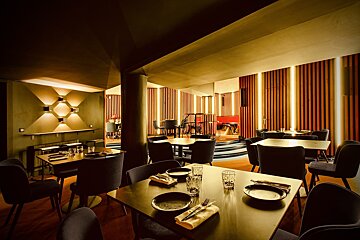 A restaurant with tables and chairs and a stage