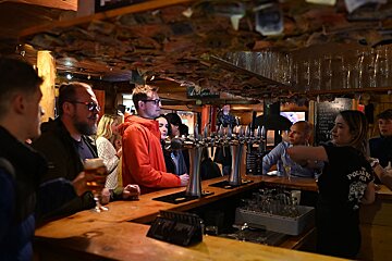 A bartender wearing a polar bear shirt pours beer