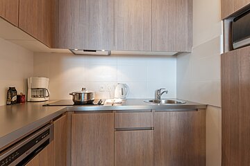 A kitchen with a pot on the stove and a coffee maker