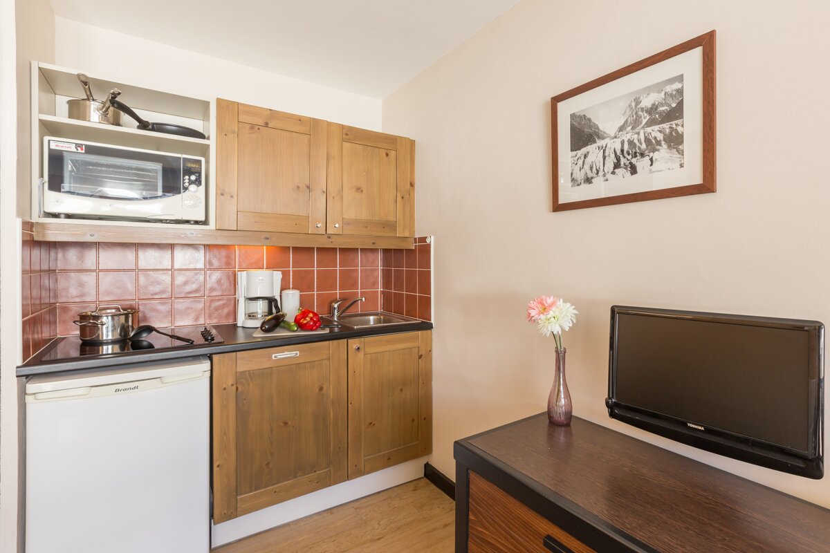 A small kitchen with a picture on the wall above it