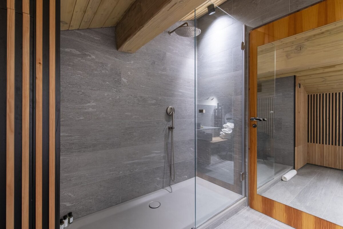 A bathroom with a walk in shower and a large mirror
