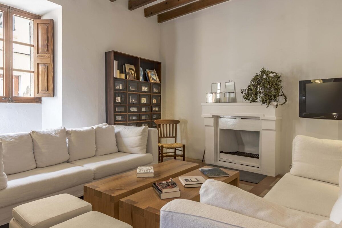 A living room with white furniture and a fireplace