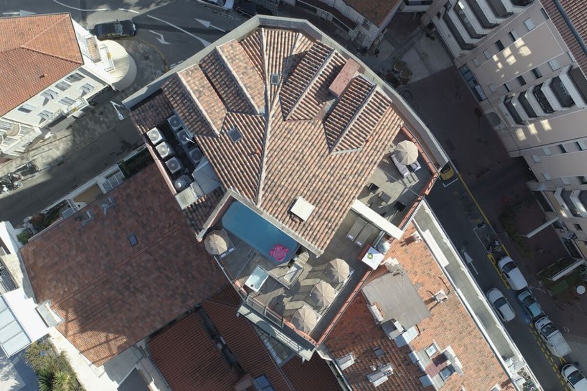 An aerial view of a building with a pool on the roof