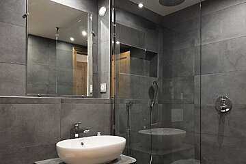 A bathroom with a sink and a walk in shower