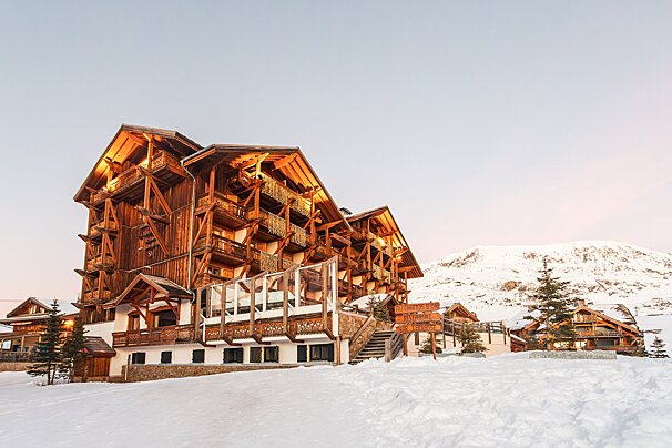 A large wooden building is surrounded by snow