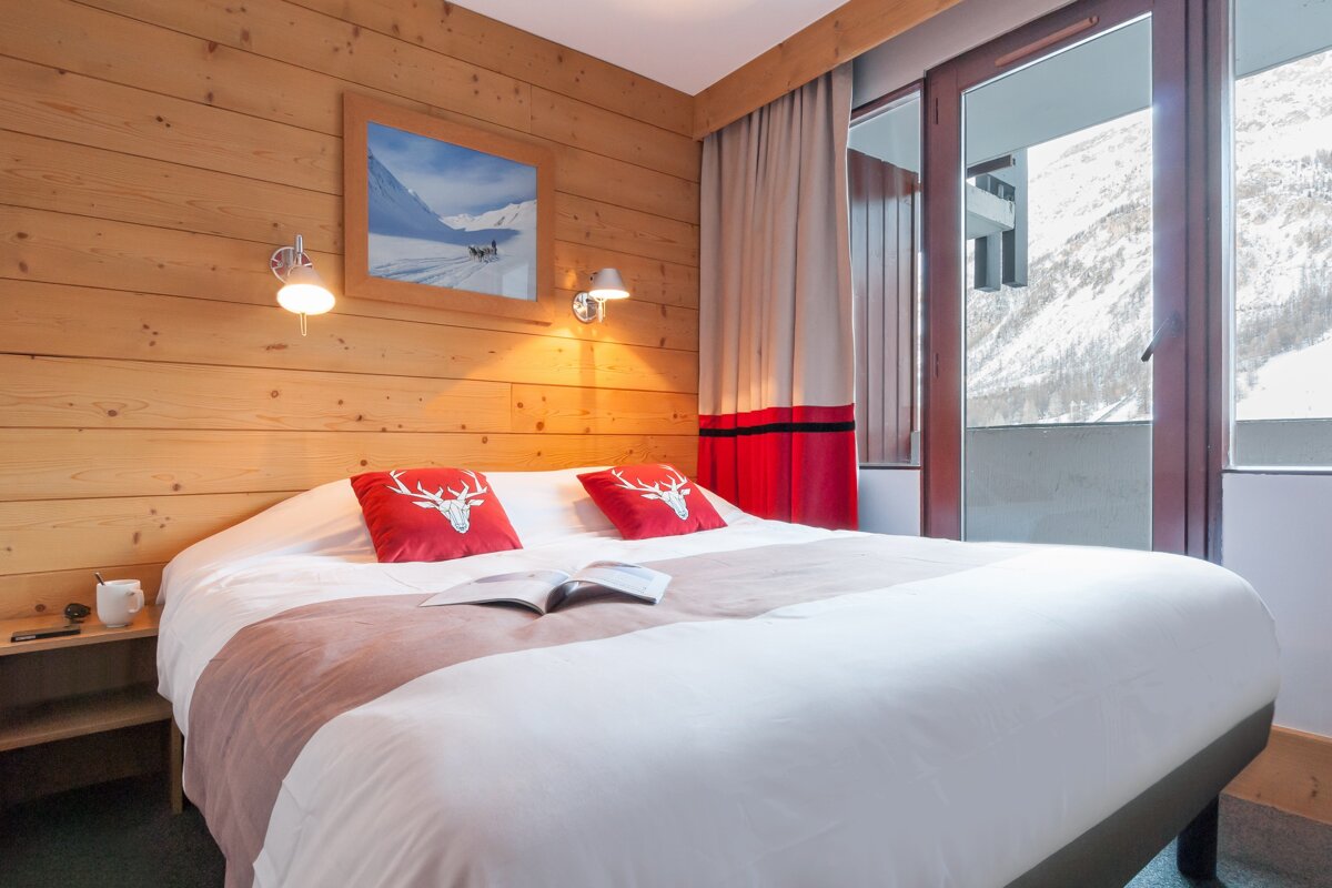A hotel room with a bed and a book on it