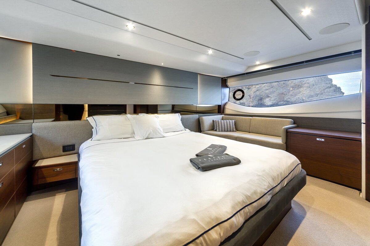A bedroom on a boat with a bed and a couch