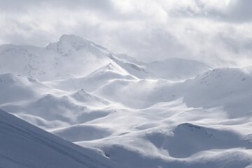 wind blowing the snow up off the mountains
