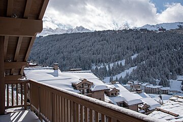 A balcony with a view of a snowy mountain range