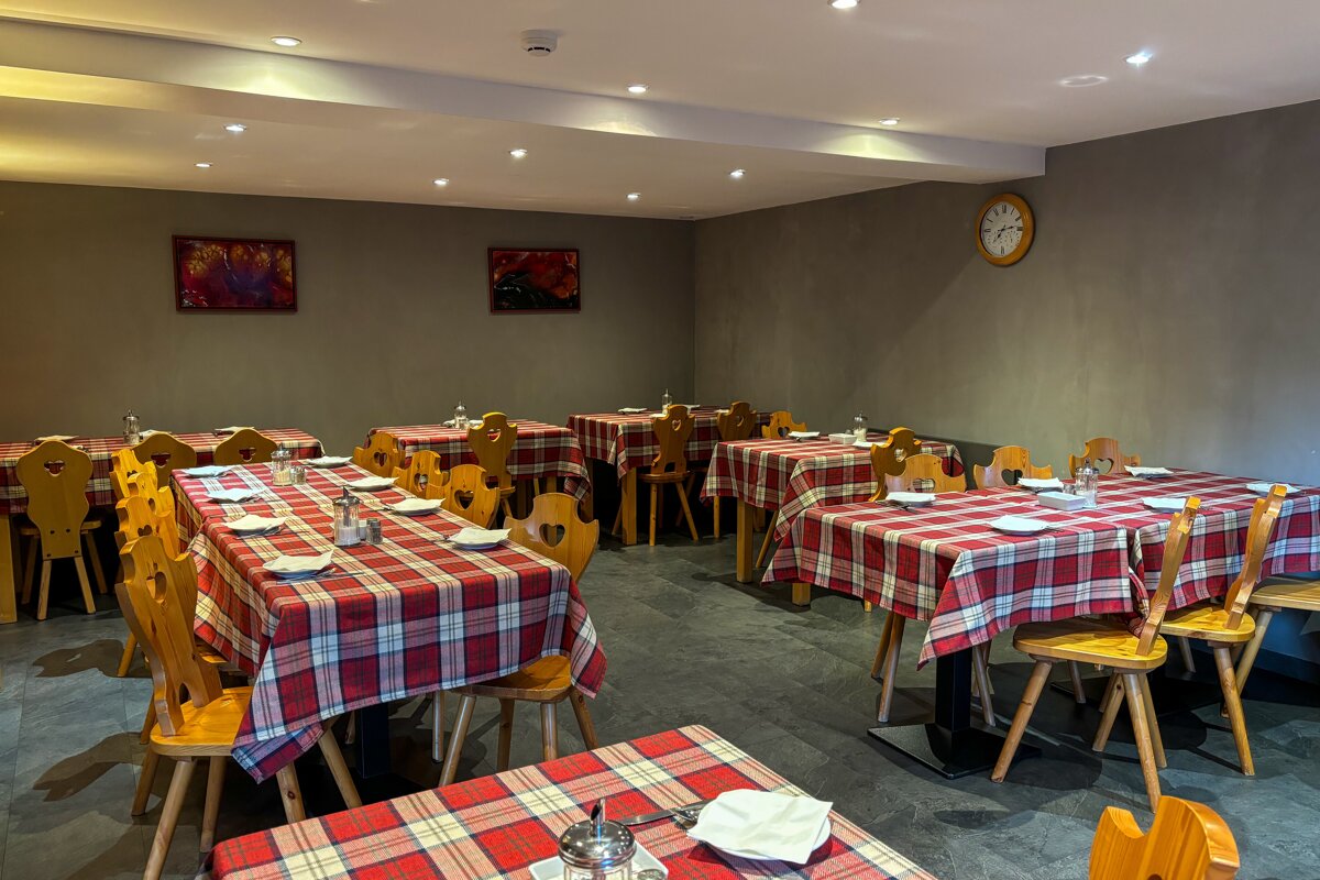 A restaurant with tables and chairs and a clock on the wall