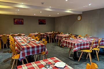 A restaurant with tables and chairs and a clock on the wall