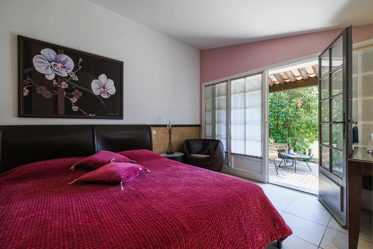 A bedroom with a bed and a picture of flowers on the wall
