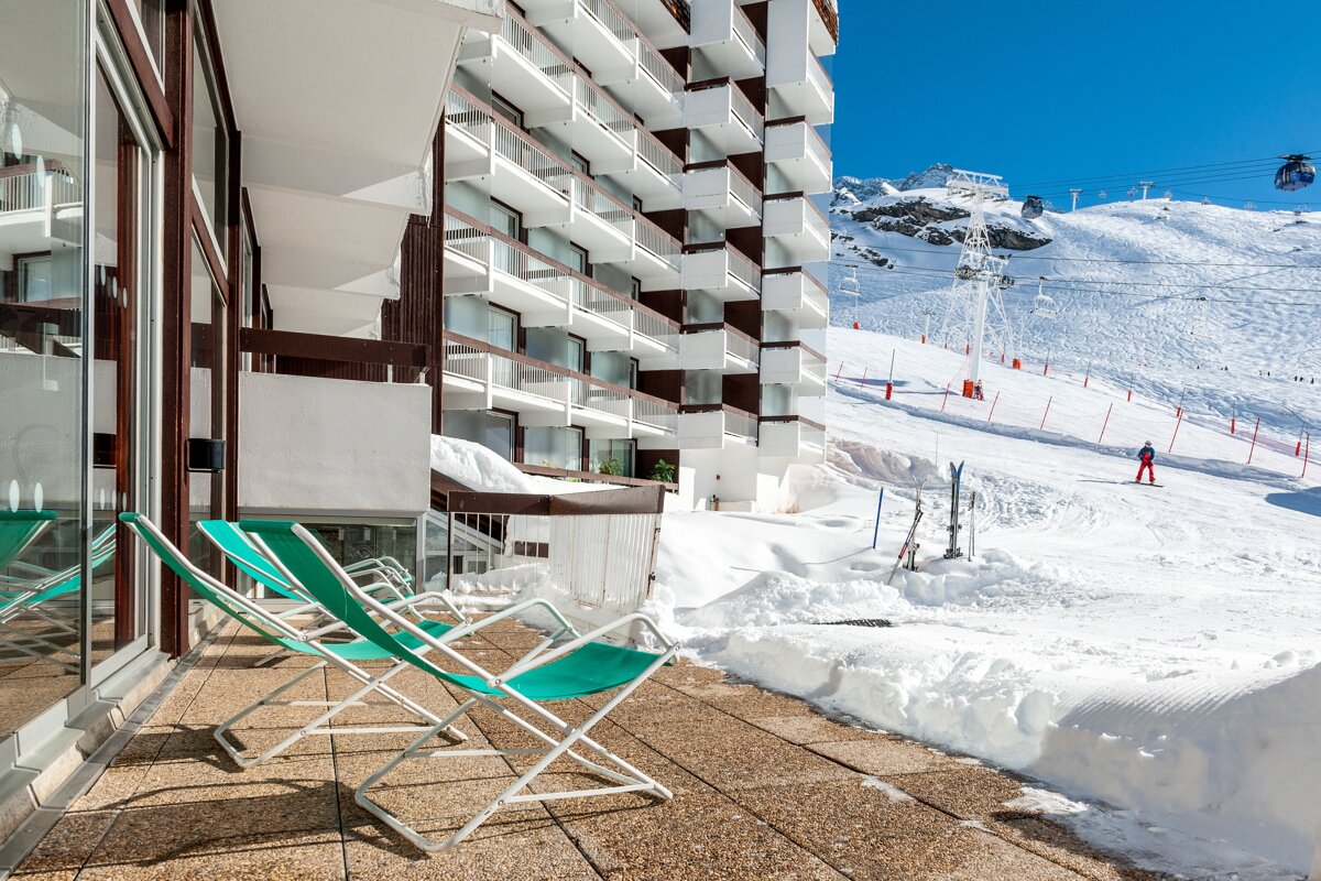 Chairs on a balcony with a ski lift in the background