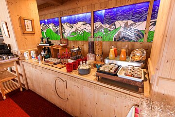 A buffet with a painting of mountains in the background