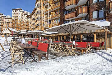 A restaurant with tables and chairs outside in the snow