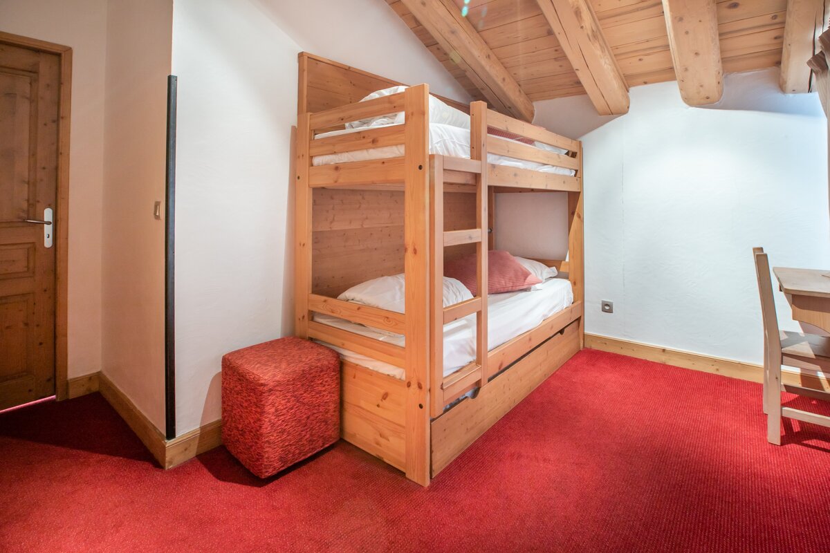 A bunk bed in a room with a red carpet