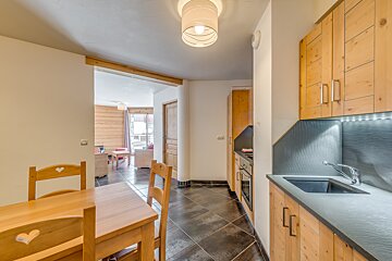 A kitchen with a table and chairs and a sink