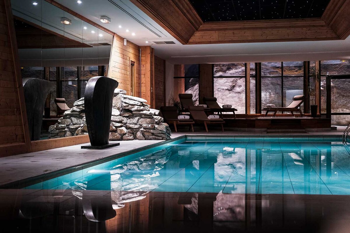 A large indoor swimming pool with a statue in the middle