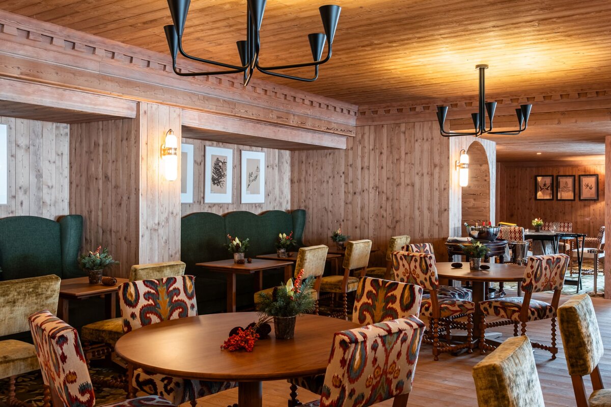 A dining room with tables and chairs and a chandelier