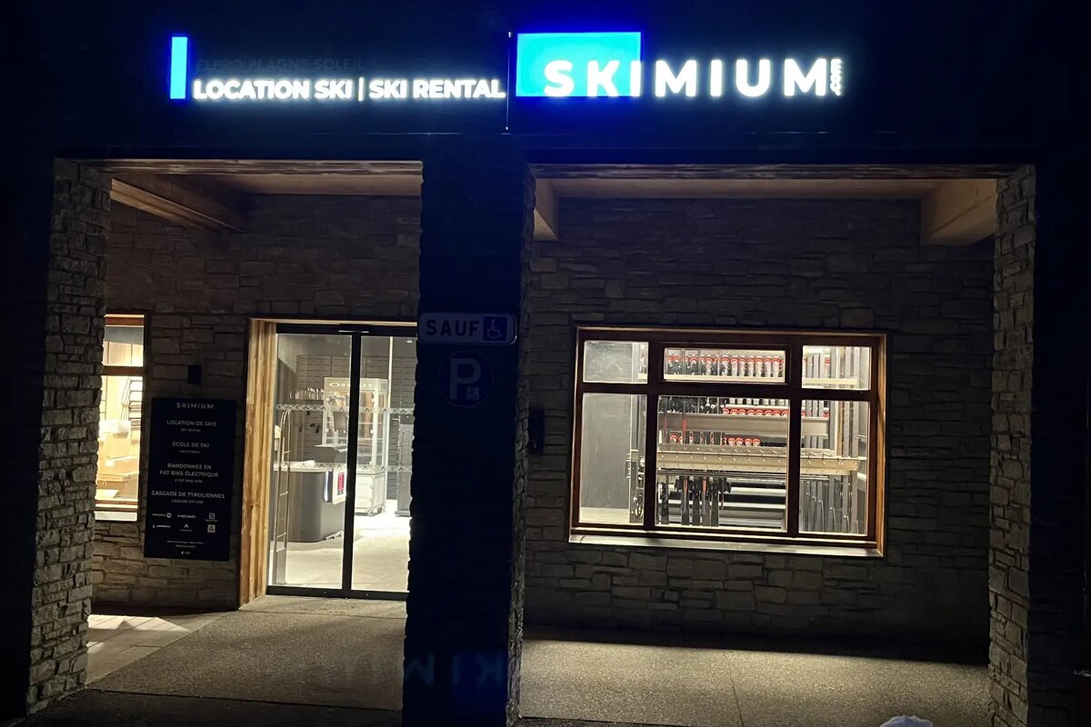 A ski rental store is lit up at night