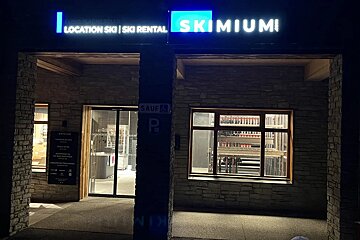 A ski rental store is lit up at night